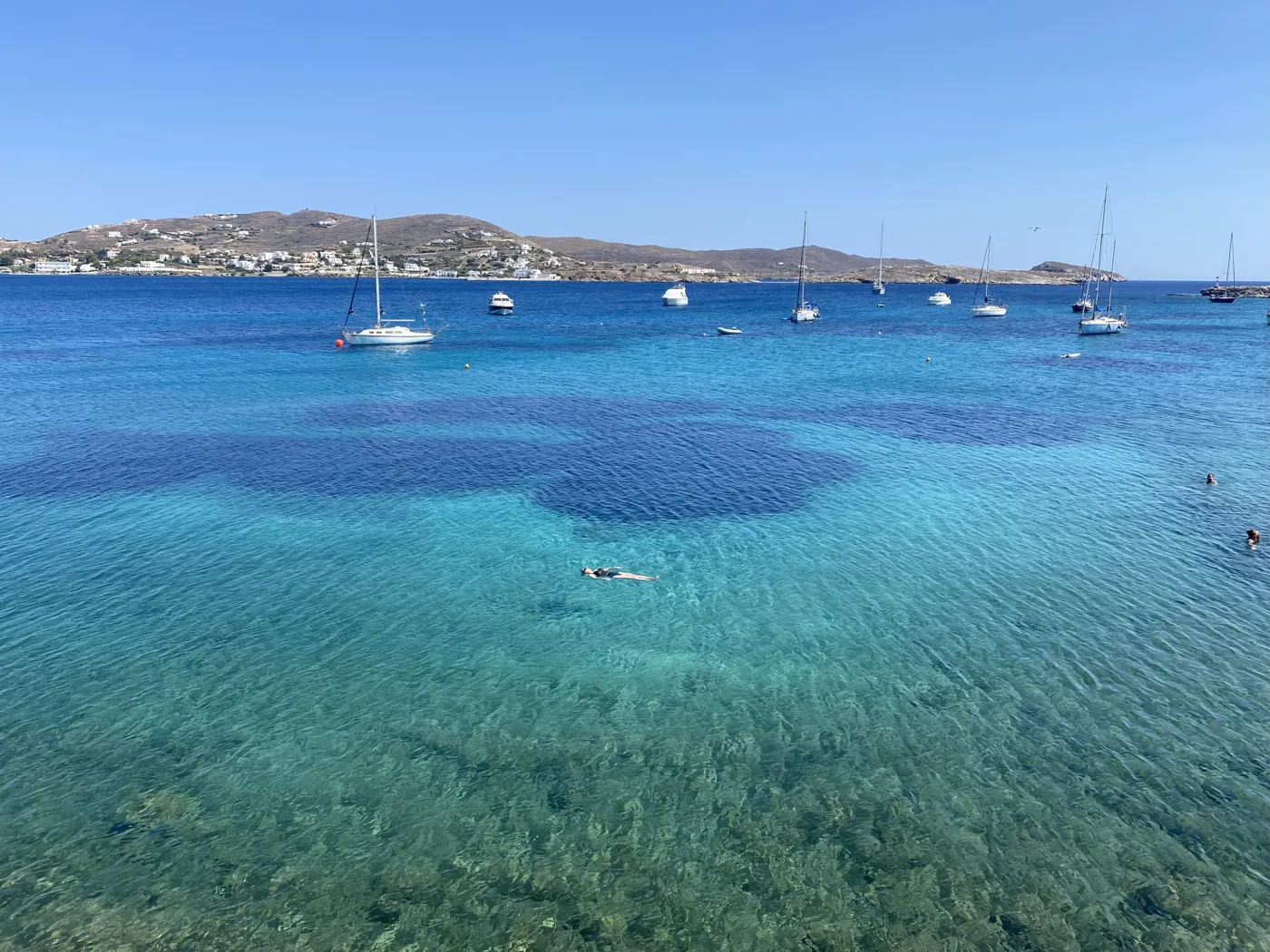 L’eau turquoise et limpide de Finikas avec des voiliers dans la baie