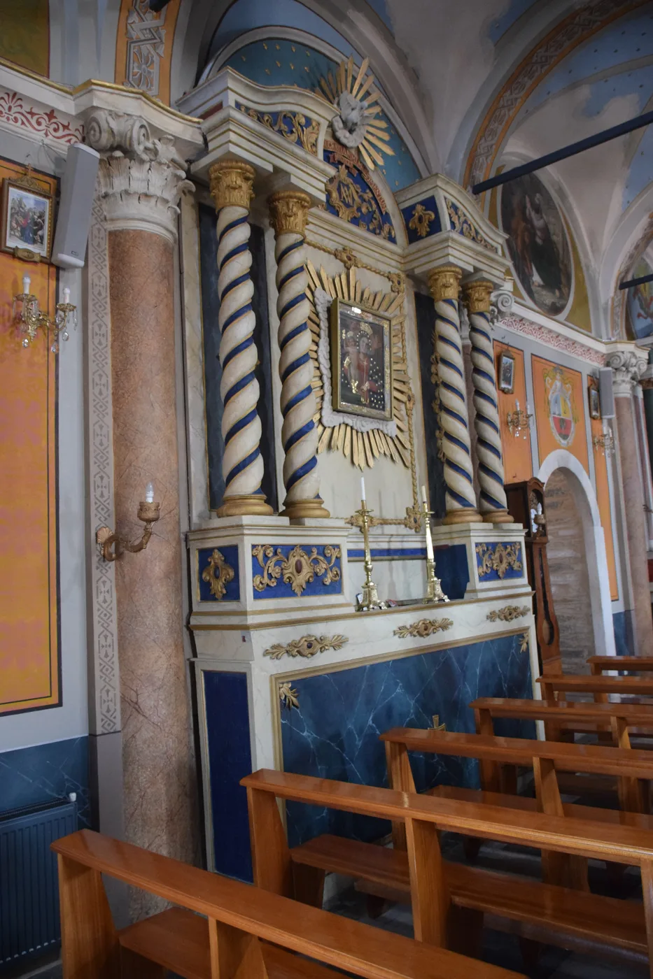 L’intérieur de l’église catholique Saint-Georges à Ano Syros, avec des colonnes de marbre et des bancs en bois