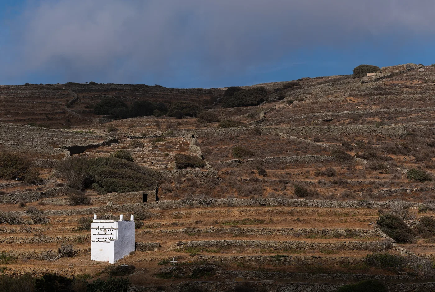 Um pombal branco entre socalcos de pedra em Tarambados