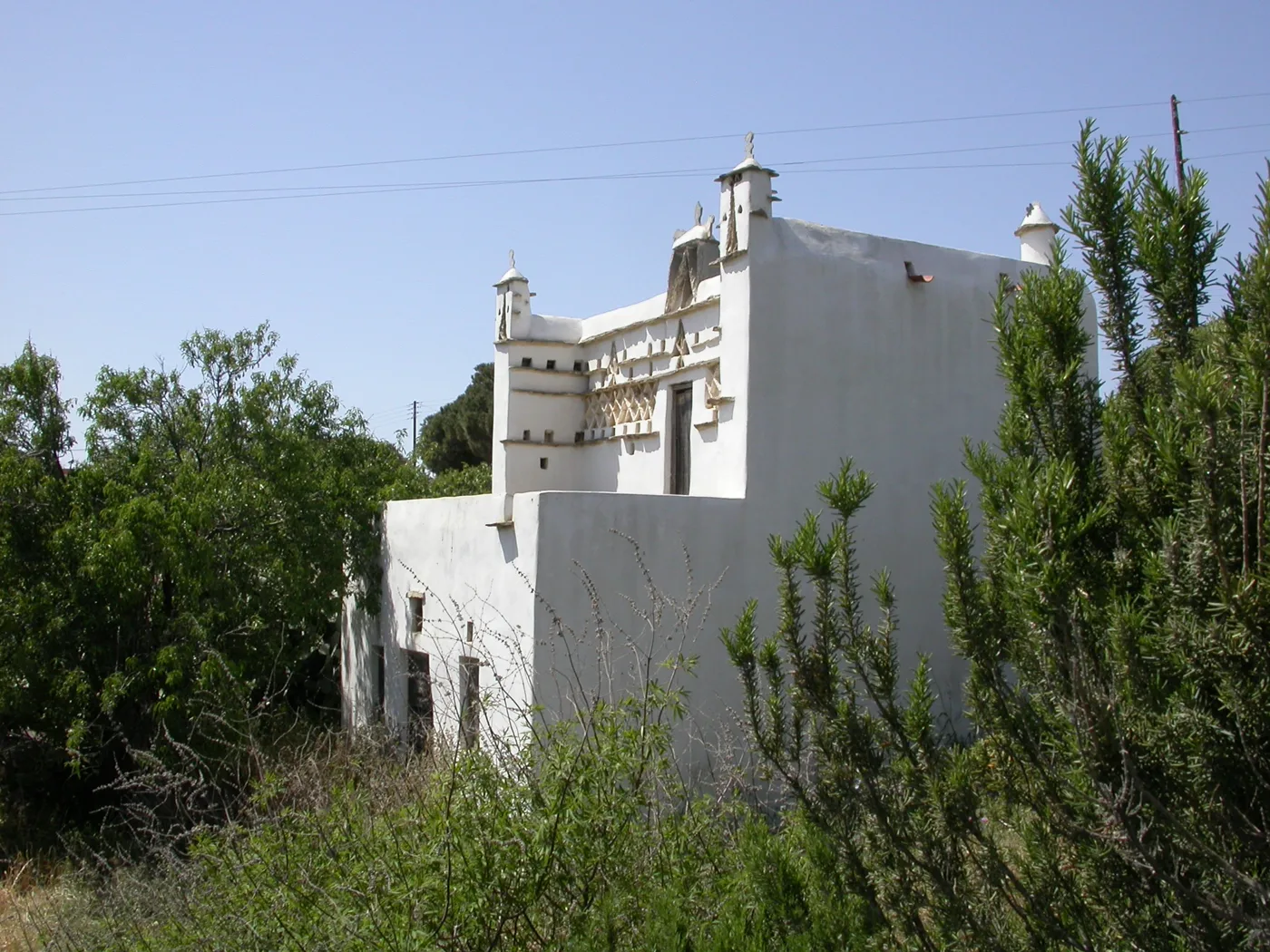 Um pombal com desenhos triangulares brancos entre árvores