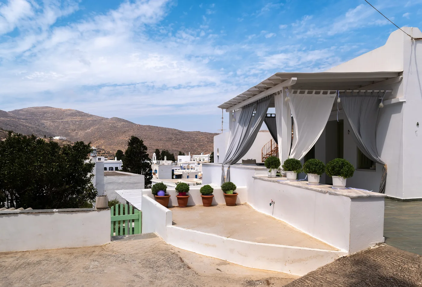 Uma casa branca com pérgula em Pyrgos, com vista para as montanhas