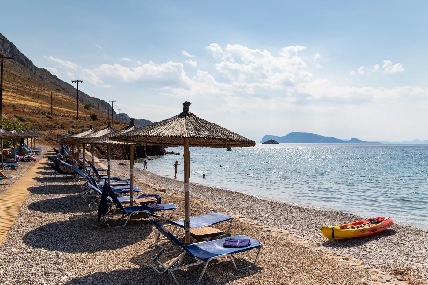 La plage de Plakes avec des parasols en paille et vue sur le large