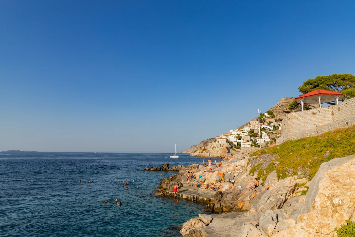 Des nageurs sur les rochers de Spilia, sous la ville