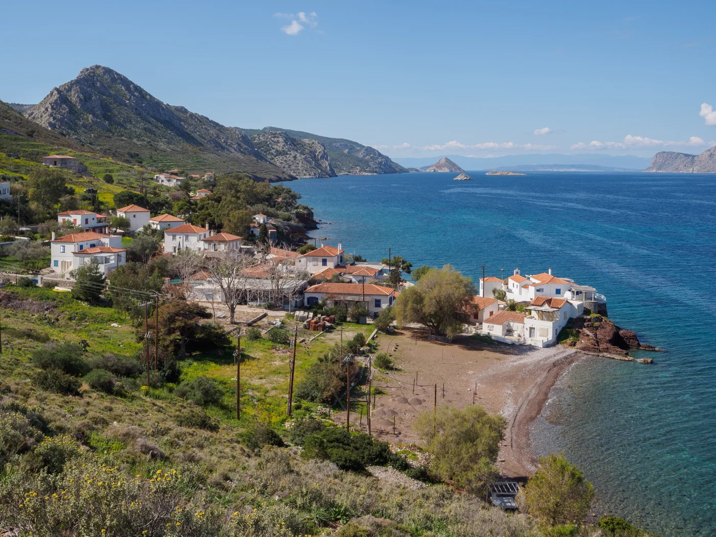 Vlychos avec des maisons, une petite plage et la mer