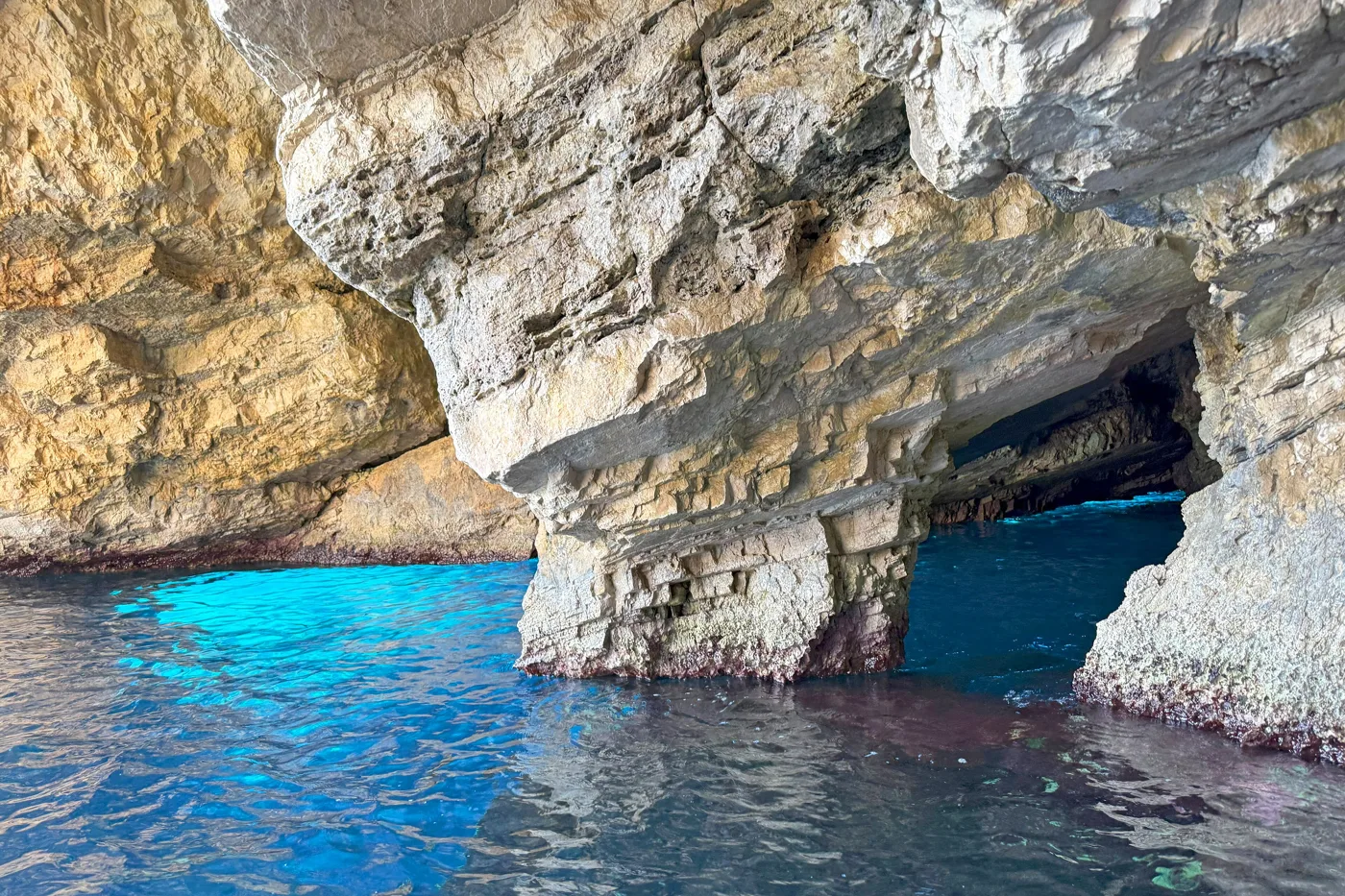 A cave entrance with glowing blue water at the Blue Caves