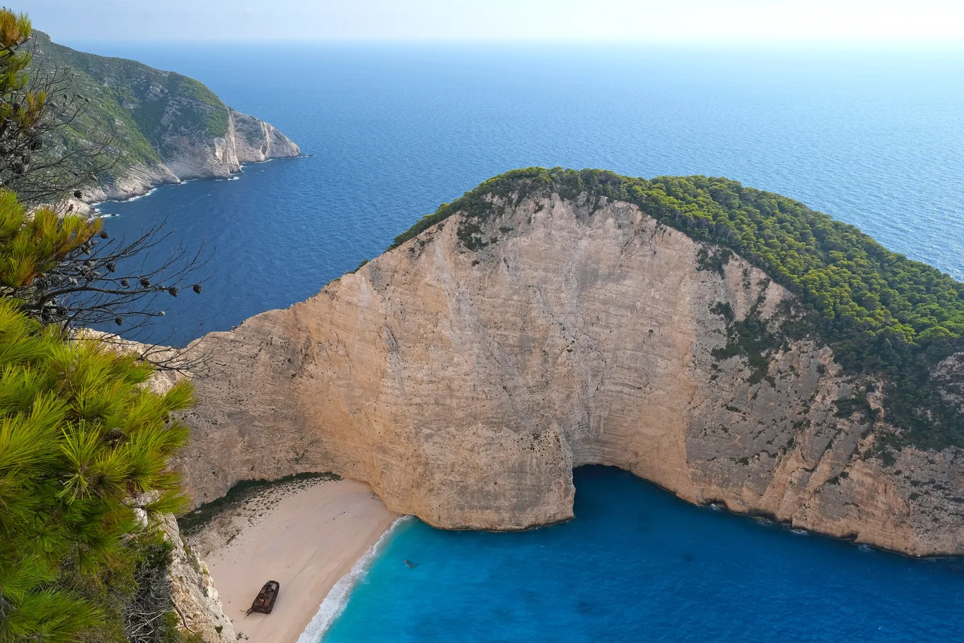 The Navagio cove with its sand and blue water, between sheer rocks