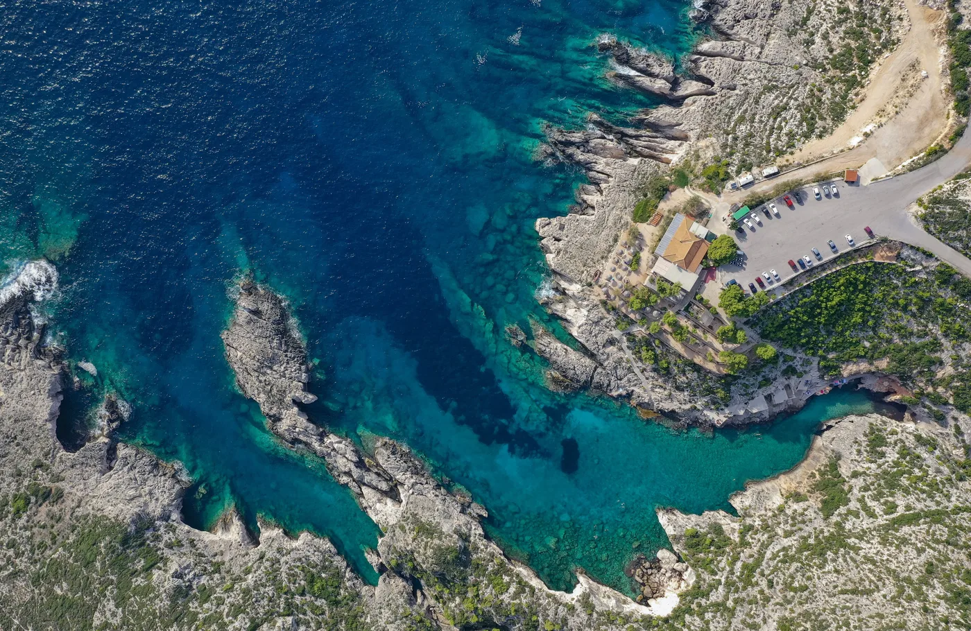 Porto Limnionas from above, a narrow inlet with deep blue water between rocks