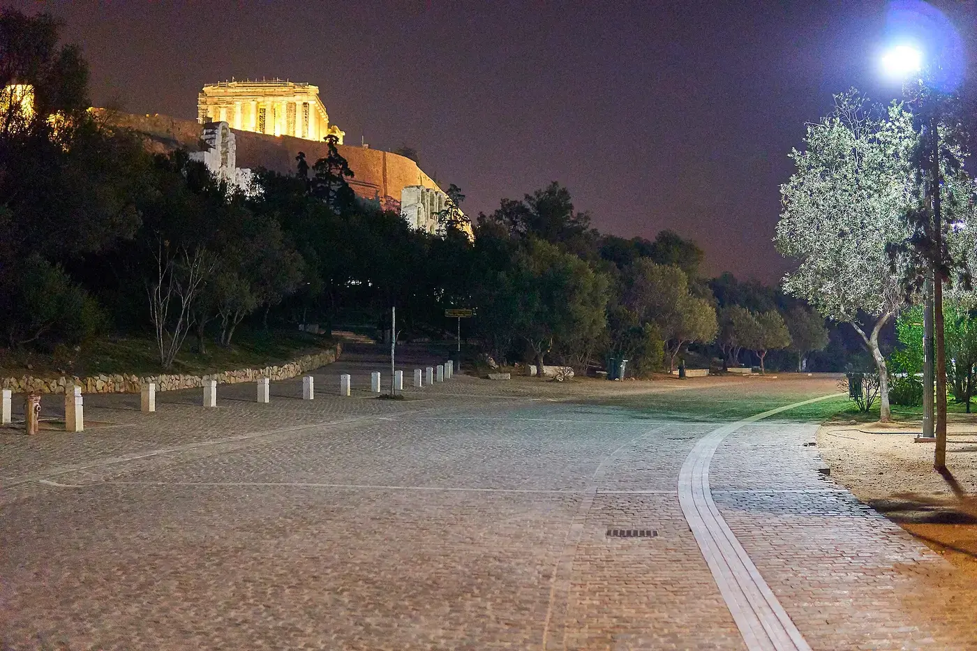 夜晚的狄奥尼修·阿雷奥帕吉图街，树梢上方是灯光照亮的卫城