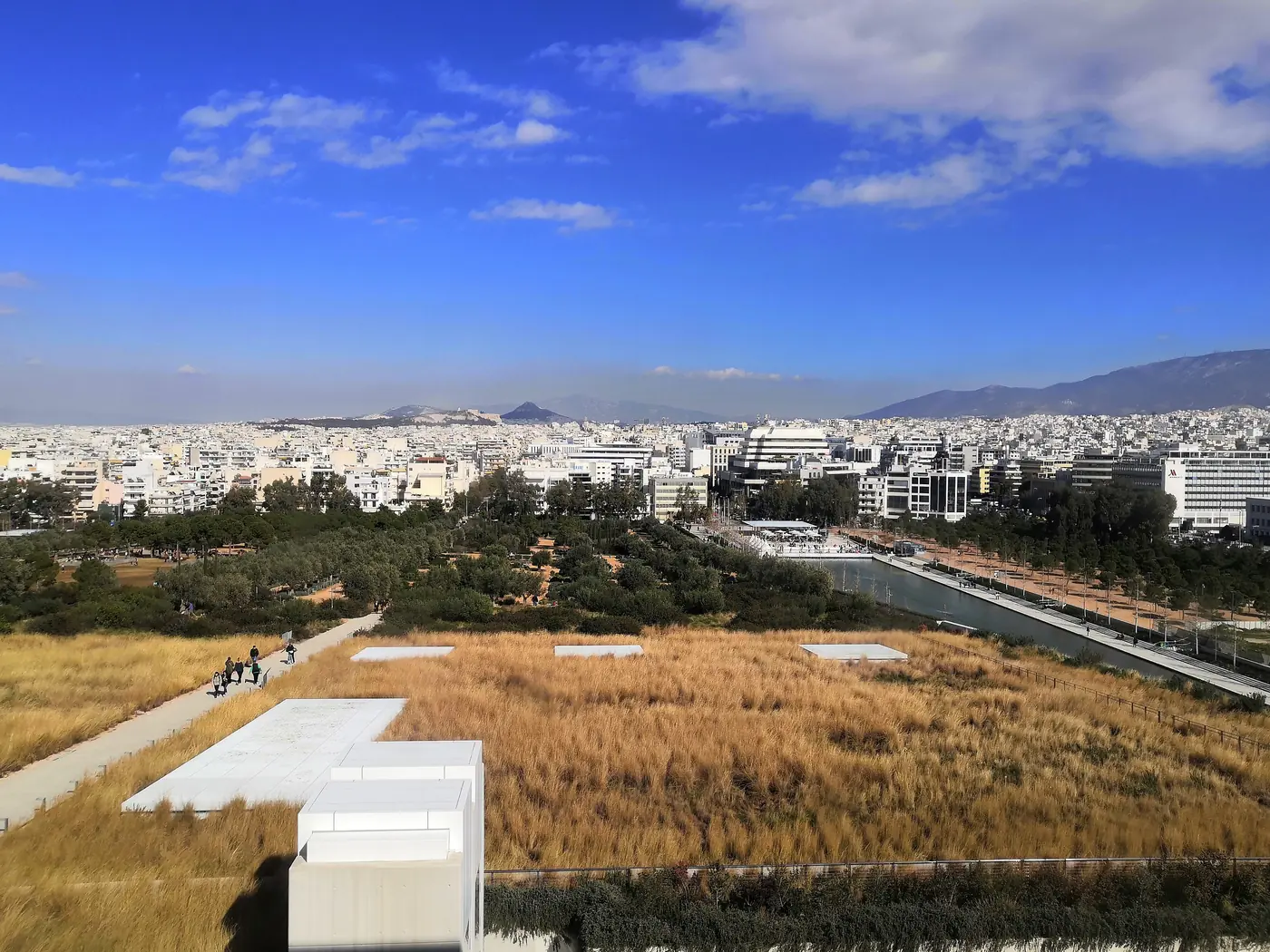 Il giardino pensile dello SNFCC con erbe secche e la città di Atene sullo sfondo
