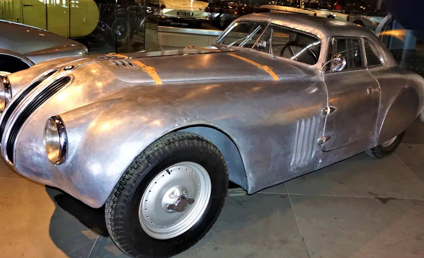 Una BMW 328 Coupé argento e aerodinamica, con strisce nere sul cofano, al Museo dell’automobile