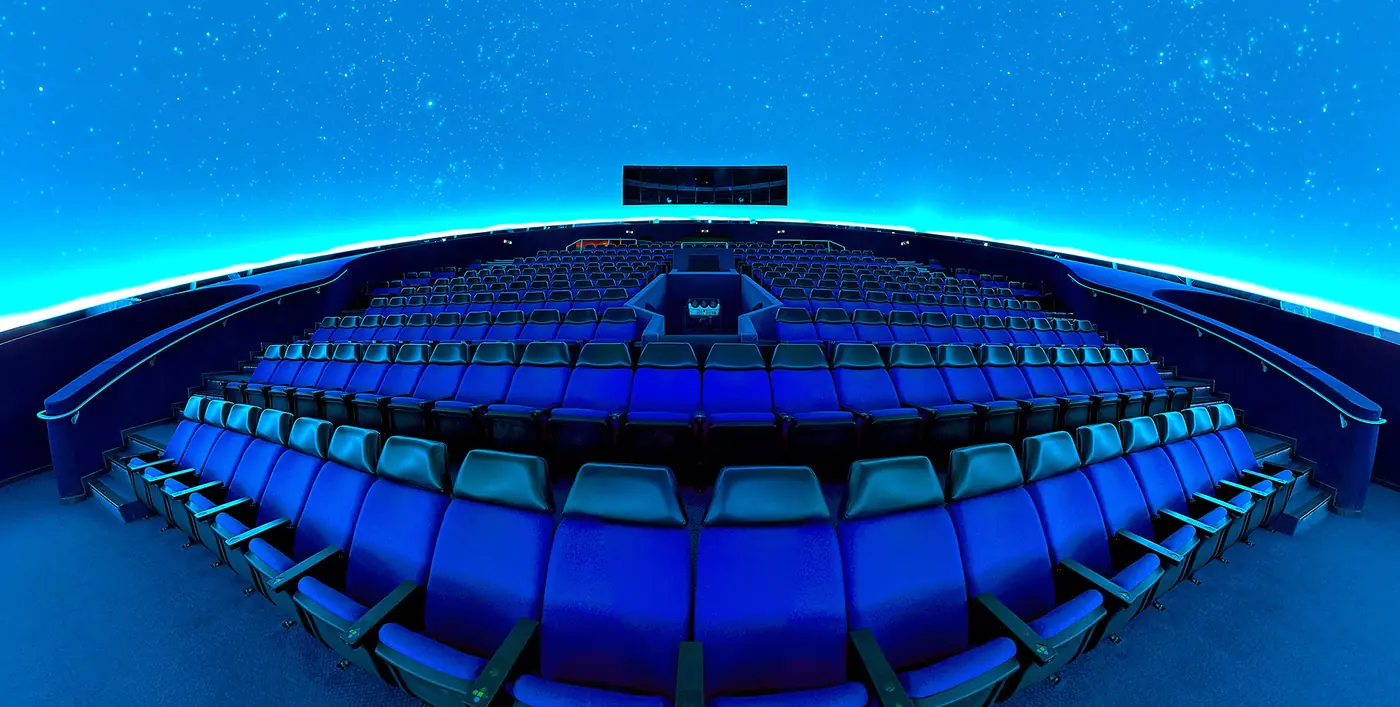 Le poltrone blu del Planetario Eugenides in file concentriche sotto la cupola con il cielo stellato