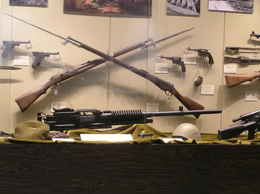 Una vetrina con fucili a baionetta incrociati, pistole e una mitragliatrice al Museo della Guerra di Atene