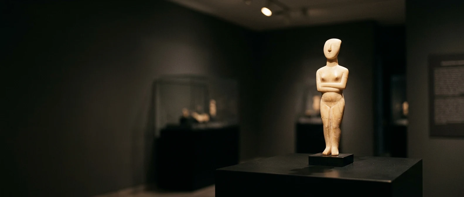 Cycladic marble figurine displayed under a single spotlight at the Museum of Cycladic Art