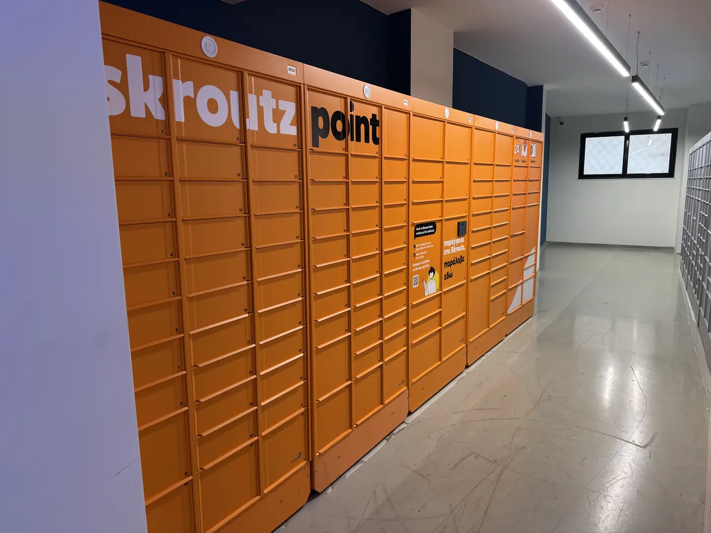 Οι πορτοκαλί θυρίδες Skroutz Point στο ισόγειο της Ιουλιανού 50